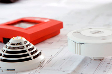 Quais são os componentes básicos de um sistema de detecção e alarme de incêndio?
